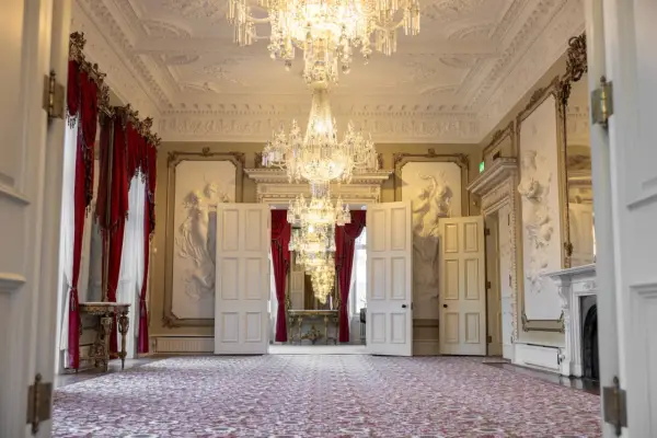 Ett elegant rum med kristallkronor och röda draperier i Dicksonska palatset.