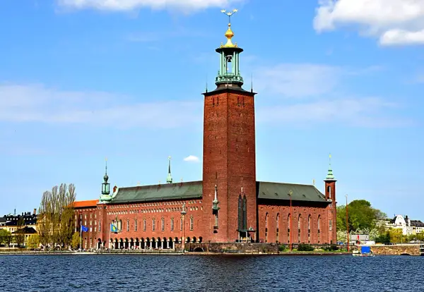 Stockholms stadshus reser sig stolt vid vattnet, dess ikoniska torn dominerar horisonten.